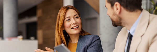 Portrait of smiling businesswoman explaining business plan to her colleague on a sprint meeting at boardroom.