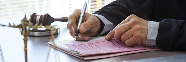 Businesswoman typing on a laptop during meeting at boardroom with her leadership team.