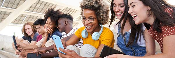 Group of young mixed race people with mobile phones. Excited students using their technological devices. Concept of young enterprising, friendly, selfie, app, hipster, millennial.